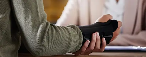 Person in Wrist Brace at Workers Compensation Lawyer Meeting